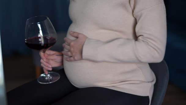 Onherkenbare Zwangere Vrouw Strelen Buik Drinken Rode Wijn Zitten Binnen — Stockvideo