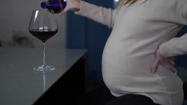 Tanımlanamayan Hamile Bir Kadın Bardağa Kırmızı Şarap Dolduruyor Mutfakta Oturmuş — Stok video