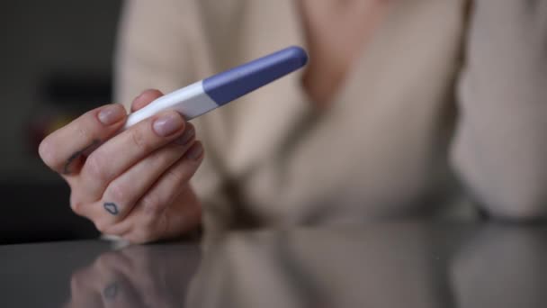 Κοντινό Τεστ Εγκυμοσύνης Στο Χέρι Μιας Νεαρής Καυκάσιας Που Κάθεται — Αρχείο Βίντεο