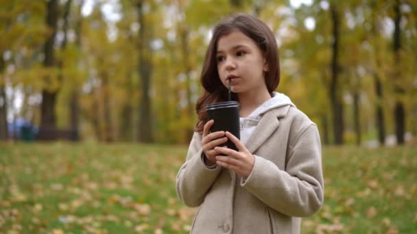 슬로우 모션에서 짚으로 커피를 마시는 귀여운 소녀의 초상화 공원에서 매력적인 — 비디오