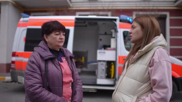 Kobieta Ciąży Komunikująca Się Sanitariuszem Pobliżu Karetki — Wideo stockowe