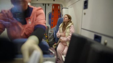 Genç hamile bir kız ambulansta tedirgin olur ve karnını sürekli okşar. Kendini ve doğmamış bebeği sakinleştirir.