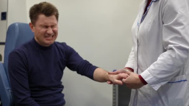 의사의 검사에서 환자는 손가락과 통증을 불평합니다 — 비디오