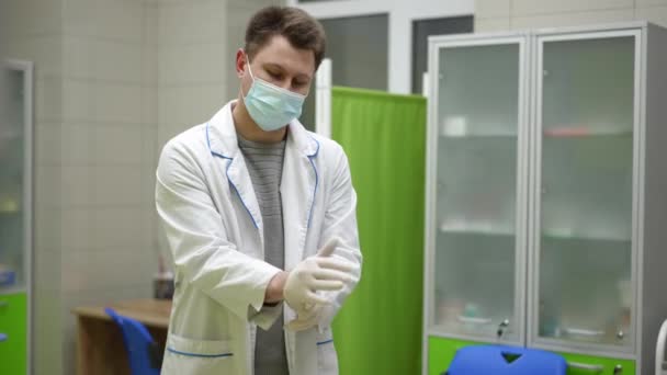 Pracownik Medyczny Ubrany Biały Płaszcz Maskę Zakłada Spodnie Medyczne Przygotowuje — Wideo stockowe