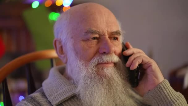 ロッキングチェアの高齢者が携帯電話で彼に連絡しようとしている — ストック動画