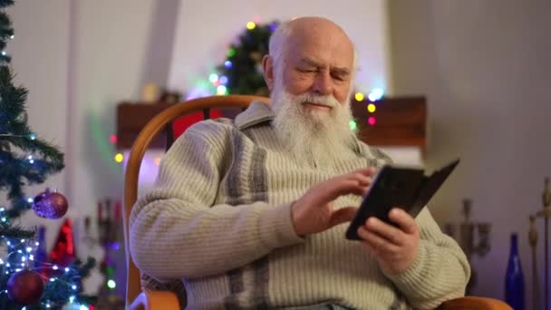 Рождество Пожилой Человек Сидящий Кресле Качалке Печатает Смешное Приветствие Свой — стоковое видео