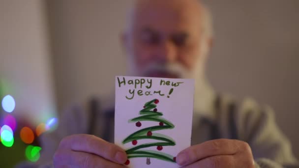 Ένας Ηλικιωμένος Γκριζομάλλης Διαβάζει Την Κάρτα Της Πρωτοχρονιάς — Αρχείο Βίντεο