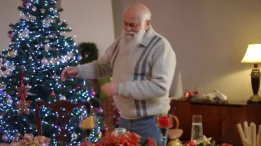 Yaşlı bir adam Noel için süslenmiş bir odaya girer. Dans ederken, bayram masasına doğru yürür, bir Noel şapkası takar, ve bir gaz çakmağının yardımıyla,