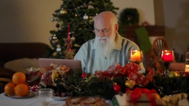 Dizüstü bilgisayarı üzerinde çalışmayı bitiren yaşlı sakallı bir adam festival masasından kalkar ve gider.