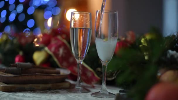 ホワイトスパークリングワインは お祝いのクリスマステーブルにシャンパングラスに注がれます クリスマスと新年のお祝いのコンセプト — ストック動画
