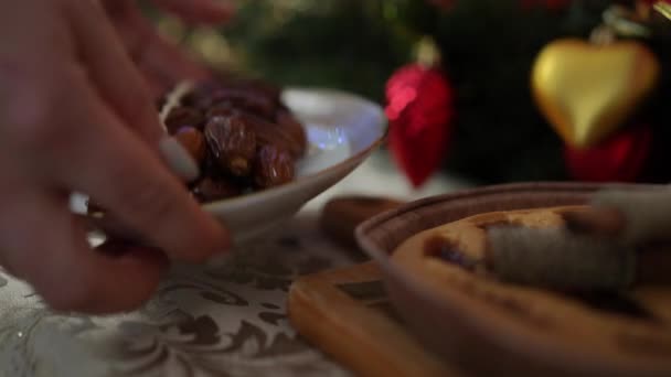 クリスマスと新年のための甘い準備 クリスマステーブルサーバー クリスマスケーキと日付の料理のクローズアップ — ストック動画
