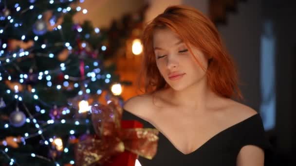 Una Joven Pelirroja Con Una Mirada Ensueño Sostiene Regalo Navidad — Vídeos de Stock
