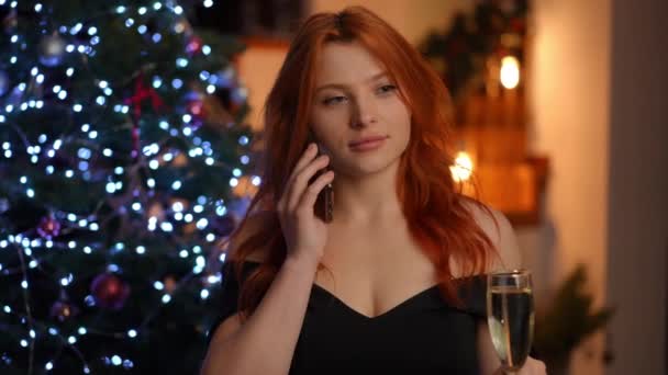 Een Mooie Vrouw Staat Naast Een Kerstboom Met Een Glas — Stockvideo