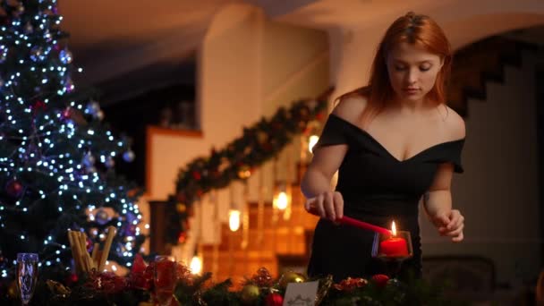 Eine Junge Rothaarige Frau Einem Schwarzen Cocktailkleid Zündet Heiligabend Eine — Stockvideo