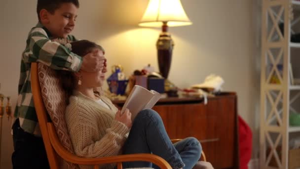 Girl Reads Book While Sitting Rocking Chair Boy Comes Her — Stock Video