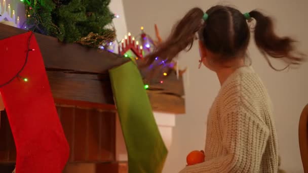 Chica Secreto Pone Una Mandarina Una Media Navidad Sobre Chimenea — Vídeos de Stock