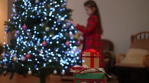 Χριστουγεννιάτικα Δώρα Στο Βάθος Από Την Εστίαση Ένα Κορίτσι Διακοσμεί — Αρχείο Βίντεο