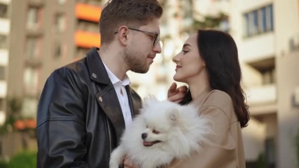 現代の住宅複合体の背景に対して犬と愛するカップルのテンダー感情 — ストック動画
