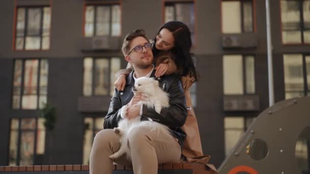 Ein Junger Mann Sitzt Mit Einem Weißen Hund Auf Dem — Stockvideo