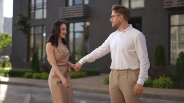 Ağır çekim. Bir erkek ve bir kadın modern bir binanın arka planında el ele tutuşuyorlar. Dans hareketleri olan bir kadın etkili bir şekilde sevgilisinin kollarına düşer.