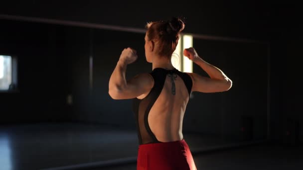训练前热身 一个女人站在舞蹈室的镜子前 用旋转的动作锻炼她的肌肉 — 图库视频影像