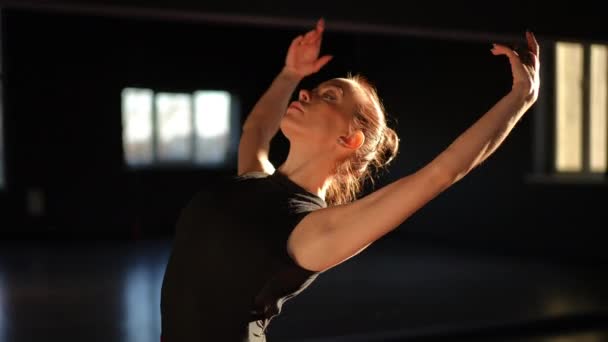 一位漂亮的芭蕾舞演员站在一个舞蹈表演大厅里 用胳膊和身体平稳地舞动着 — 图库视频影像