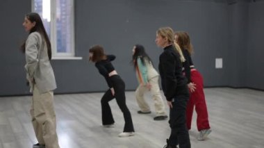 Bir dans grubunda grup kursu. Takım, öğretmenin ardından tüm hareketleri ahenkli bir şekilde tekrarladığında sevinç içindedir.