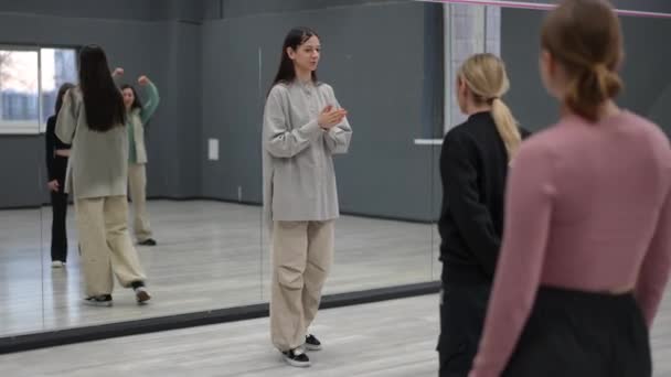 女性インストラクターが振付ホールでグループダンス演習を行います 教師のマスタークラスを見る5人の生徒 — ストック動画