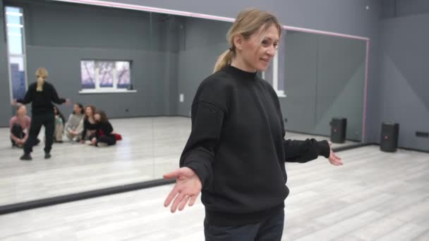 一位女教师告诉一群学生舞蹈的原理 五个学生在舞厅里围成一圈 聚精会神地听老师讲 — 图库视频影像