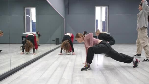 姑娘们在跳舞跳舞前参加热身班 6个年轻姑娘站在镜子前做腿部肌肉伸展运动 — 图库视频影像