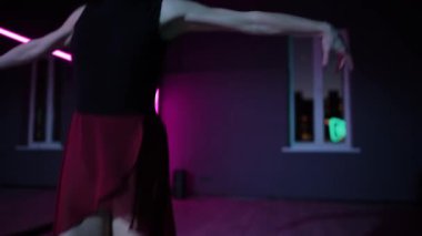 Canlı kamera. Güzel bir balerin koreografik salonda neon ışıklarıyla dans eder. Dans eden bir kadının zarif bale hareketleri.