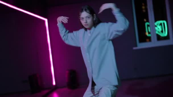 现场摄像头 一个女孩用霓虹灯在黑暗的舞厅里跳着现代舞 — 图库视频影像