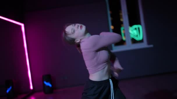 现场摄像头 一个有才华的女孩跳舞当代 一个年轻的舞者 带着霓虹灯照明的镜子在舞厅里跳舞 — 图库视频影像