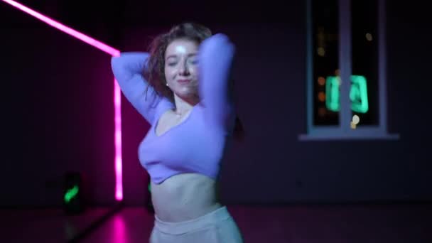 ライブカメラ 熟練した踊る才能ある少女 ネオンが照らした鏡を持つ振付ホールの若いダンサー — ストック動画