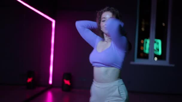 现场摄像头 一个舞者在有霓虹灯照明的舞蹈厅里巧妙地跳着现代舞 — 图库视频影像