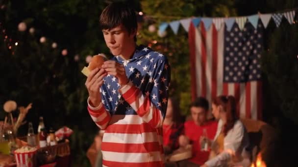 Bir Genç Arkadaşlarıyla Açık Hava Partisinde Seve Seve Hamburger Yer — Stok video