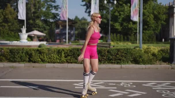 Dziewczyna Okularach Stojąca Wrotkach Kręci Się Parku Miejskim Świeżym Powietrzu — Wideo stockowe
