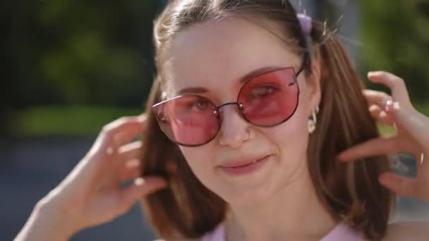 Κοντινό Πλάνο Ενός Κοριτσιού Γυαλιά Ηλίου Χαμογελώντας Ισιώνοντας Τις Κοτσίδες — Αρχείο Βίντεο