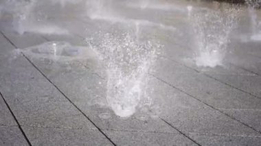 Şehre kurulmuş modern kuru bir çeşmenin çalışması sırasında su jetlerinin güzelliği ve zarafeti.