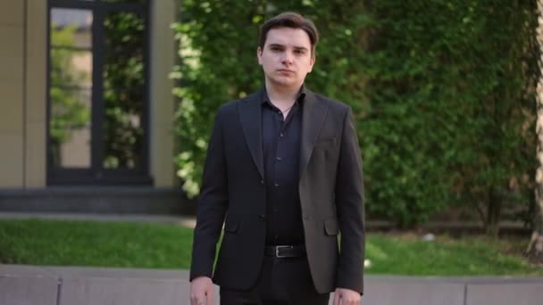 Ein Ernster Junger Mann Dunklen Anzug Posiert Mit Verschränkten Armen — Stockvideo
