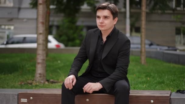 Ein Junger Mann Anzug Mit Ernstem Gesicht Sitzt Auf Einer — Stockvideo
