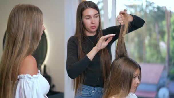 一个专业的理发师女人把她的经验和技巧传授给一个新来的理发师 美发沙龙的理发研讨会 — 图库视频影像