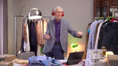 Kulaklık takan yaşlı bir adam evdeki çalışma odasında müzik dinliyor ve dans ediyor. Adam gülümsüyor, ellerini müziğin ritmine göre hareket ettiriyor ve masaüstündeki açık tablete bakıyor..