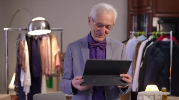 Stylish Elderly Man Glasses Standing Dressing Room Holds Tablet His — Stock Video