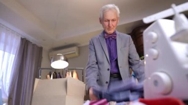 Yaşlı bir moda tasarımcısı masasındaki karton kutuya mavi bir gömlek koyar. Toplanmayı bitirdikten sonra, adam kutuyu eline aldı ve gitti..