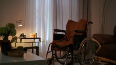 Engelli birinin yaşadığı modern bir evdeki oturma odasının durağan bir resmi. Tekerlekli sandalye evin arka planında.