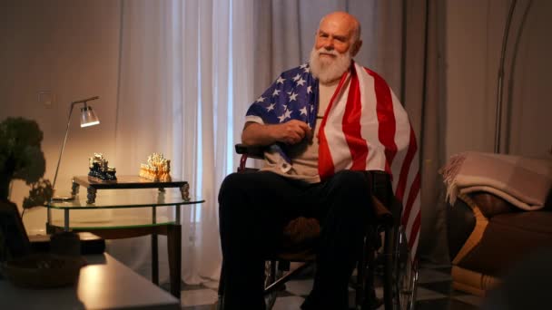 Одинокий Пожилой Инвалид Футболке Сидит Скрещенными Руками Завернутый Американский Флаг — стоковое видео