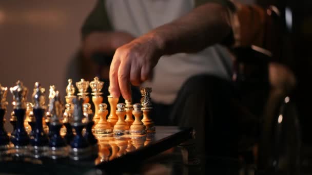 クローズアップ 年配の男性が車椅子に座っている間 チェスボード上の作品を手で移動します — ストック動画
