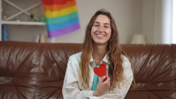 Dziewczyna Długimi Włosami Siedzi Kanapie Pokoju Trzyma Ręku Czerwone Kartonowe — Wideo stockowe