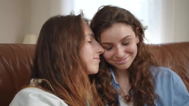 在一间现代化的房子的客厅里 一个女朋友的温柔的拥抱 姑娘们正坐在皮革沙发上 后续行动 — 图库视频影像